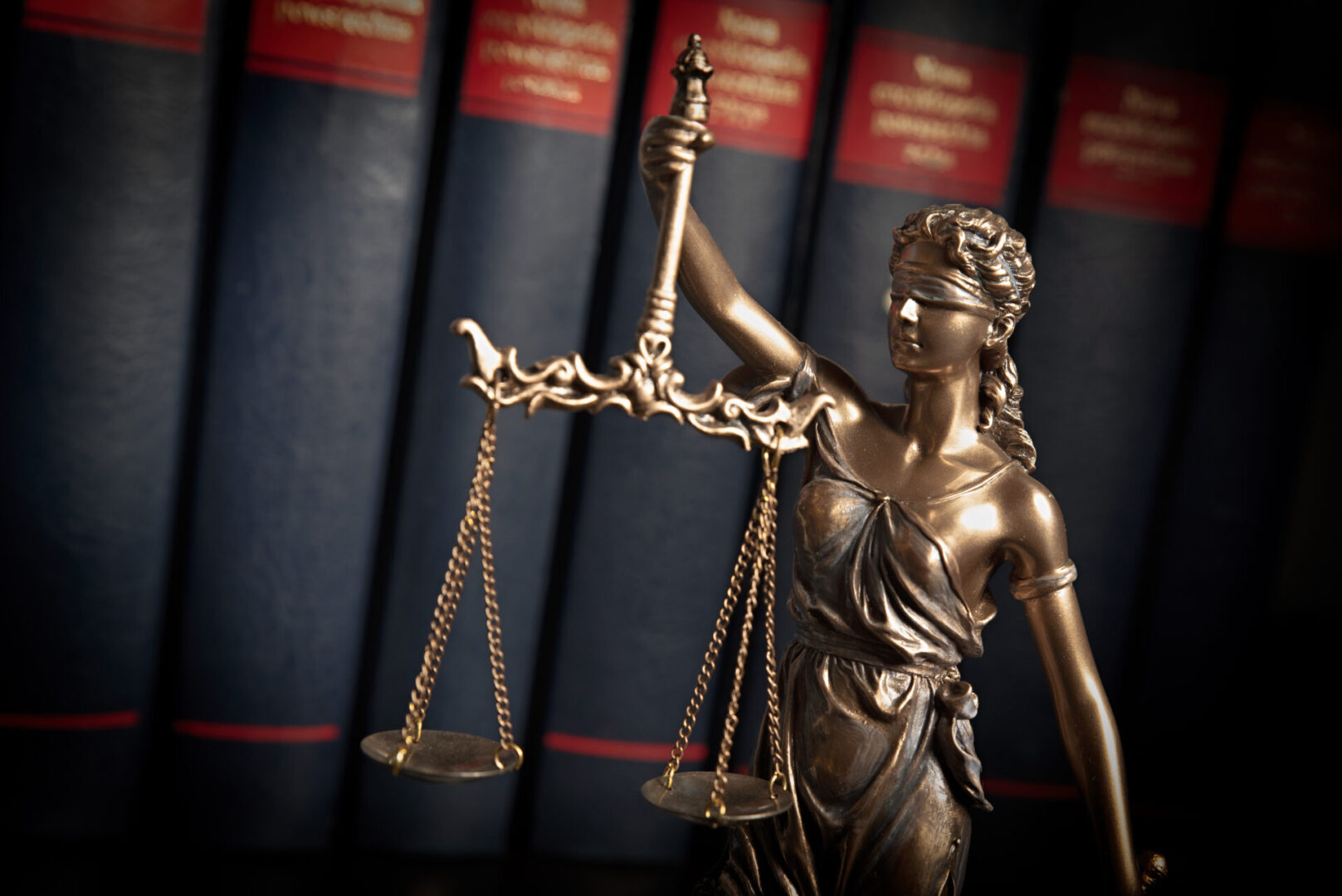 Lady justice, themis, statue of justice on books background. Law concept with justice figurine in library